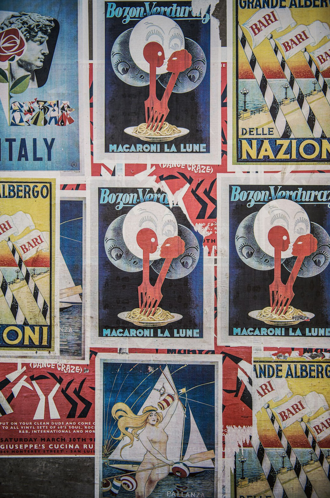 Wall covered with layered vintage advertising posters and print campaigns